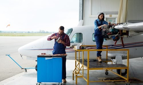 Team of aircraft engineers repairing parts of jet