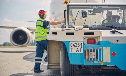 Back view of two airport male workers looking at the airliner landed at the aerodrome